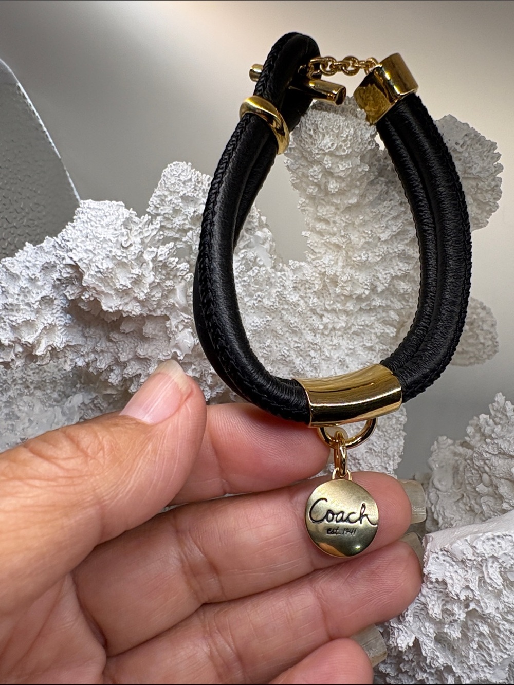 Coach Gold-Tone Charm on a Black Bracelet